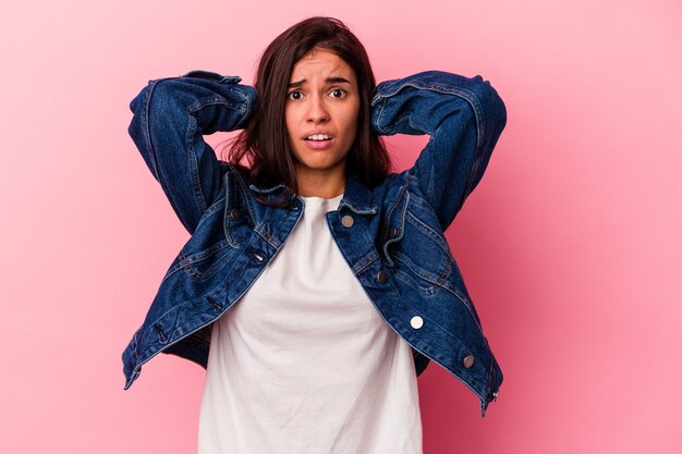 Joven mujer caucásica aislada sobre fondo rosa gritando de rabia.