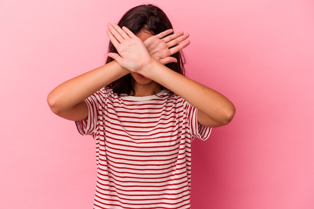 Foto joven mujer caucásica aislada sobre fondo rosa manteniendo dos brazos cruzados, concepto de negación.