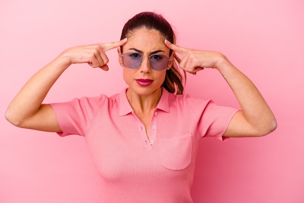 Foto joven mujer caucásica aislada sobre fondo rosa mostrando una expresión de bienvenida.