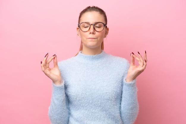 Foto joven mujer caucásica aislada sobre fondo rosa en pose zen