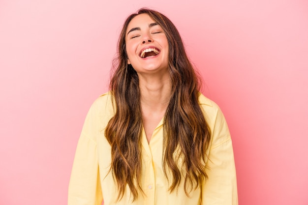 Joven mujer caucásica aislada sobre fondo rosa relajado y feliz riendo, cuello estirado mostrando los dientes.