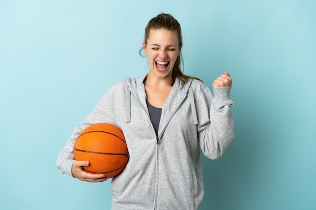 Joven mujer caucásica en azul jugando baloncesto