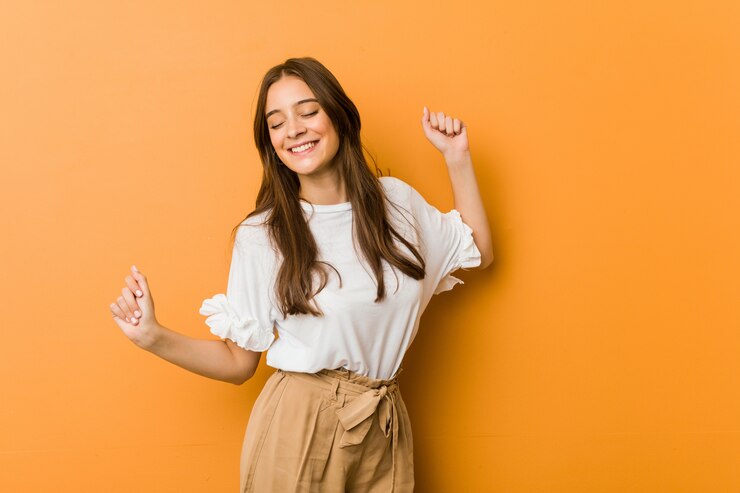 Foto joven mujer caucásica bailando y divirtiéndose.