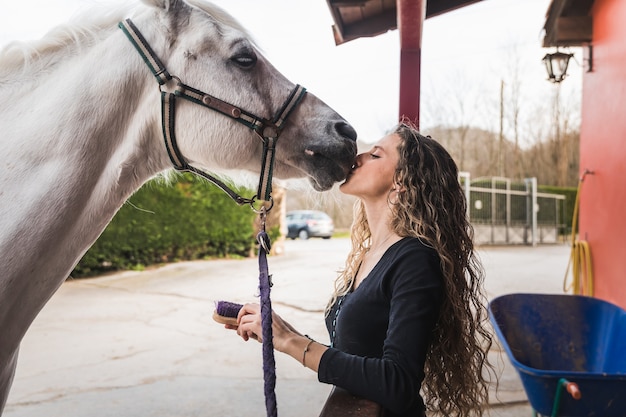 Joven, mujer caucásica, besar, un, caballo