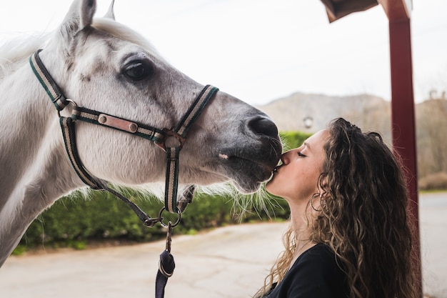 Joven, mujer caucásica, besar, un, caballo