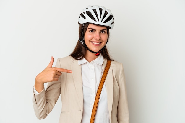 Joven mujer caucásica en bicicleta para trabajar aislado sobre fondo blanco persona apuntando con la mano a un espacio de copia de camisa, orgulloso y seguro