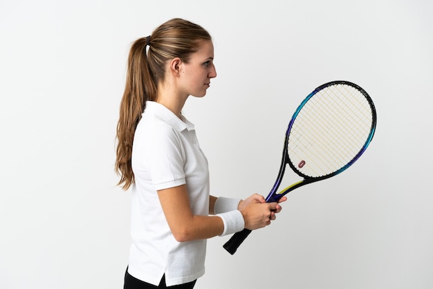 Joven mujer caucásica en blanco jugando al tenis