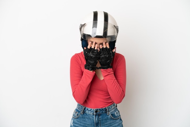 Joven mujer caucásica con un casco de motocicleta aislado sobre fondo blanco con expresión cansada y enferma