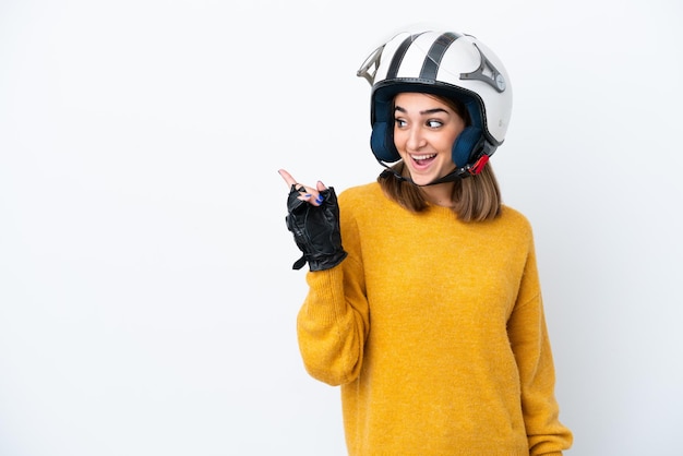 Joven mujer caucásica con un casco de motocicleta aislado sobre fondo blanco con la intención de darse cuenta de la solución mientras levanta un dedo hacia arriba