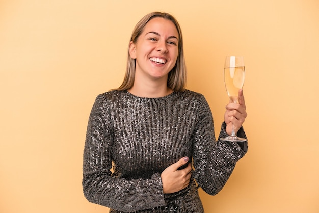 Joven mujer caucásica celebrando el año nuevo aislado sobre fondo amarillo riendo y divirtiéndose.