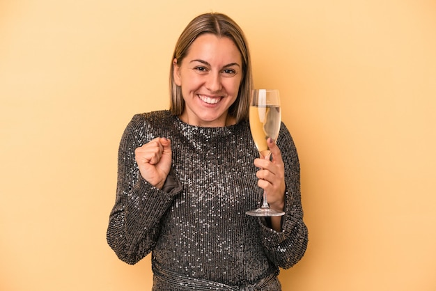 Joven mujer caucásica celebrando el año nuevo aislado sobre fondo amarillo