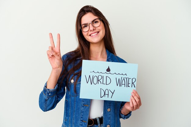 Joven mujer caucásica celebrando el día mundial del agua aislado en rosa soñando con lograr metas y propósitos