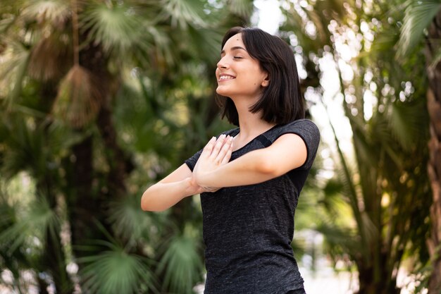 Joven mujer caucásica de deporte en posición zen al aire libre en un parque