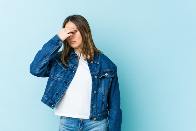 Joven mujer caucásica con dolor de cabeza, tocando el frente de la cara.