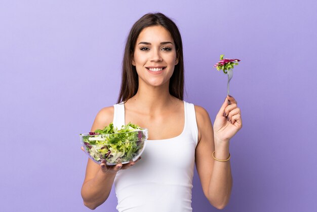 Foto joven mujer caucásica con ensalada en púrpura