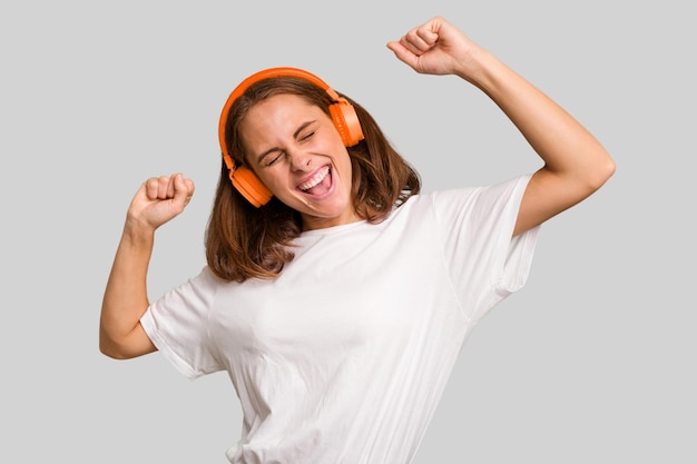 Joven mujer caucásica escuchando música con auriculares aislados