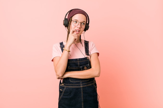 Joven mujer caucásica escuchando música relajada pensando en algo mirando un espacio de copia.