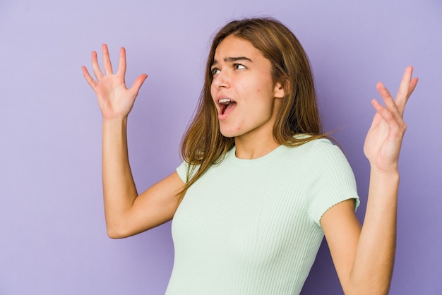 Foto joven mujer caucásica flaca en púrpura gritando al cielo, mirando hacia arriba, frustrado.