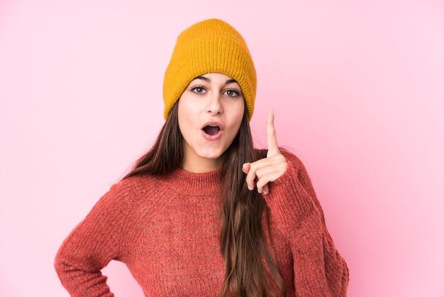 Joven mujer caucásica con un gorro de lana con una idea, concepto de inspiración.