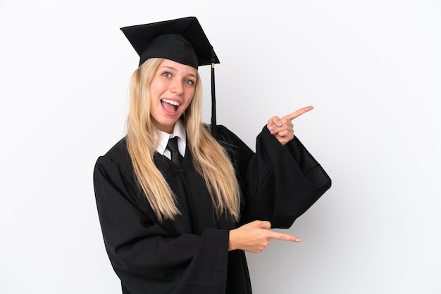 Joven mujer caucásica graduada de la universidad aislada de fondo blanco señalando con el dedo hacia un lado y presentando un producto