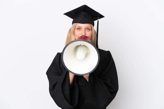 Joven mujer caucásica graduada universitaria aislada de fondo blanco gritando a través de un megáfono