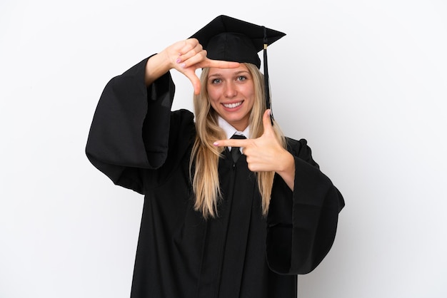 Joven mujer caucásica graduada universitaria aislada sobre fondo blanco enfocando la cara Símbolo de encuadre