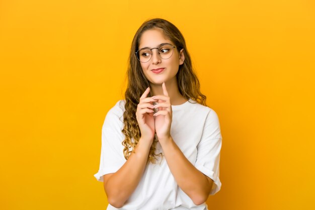 Joven mujer caucásica inventando un plan en mente, creando una idea.