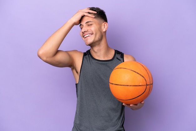 Joven mujer caucásica jugador de baloncesto hombre aislado sobre fondo púrpura sonriendo mucho