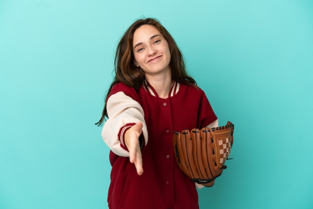 Foto joven mujer caucásica jugando béisbol aislado sobre fondo azul un apretón de manos para cerrar un buen trato