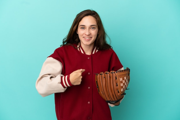 Joven mujer caucásica jugando béisbol aislado sobre fondo azul con expresión facial sorpresa