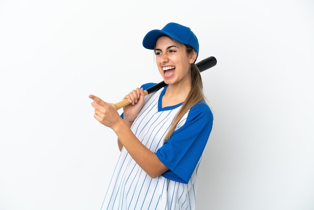 Joven mujer caucásica jugando béisbol aislado sobre fondo blanco apuntando con el dedo hacia un lado y presentando un producto