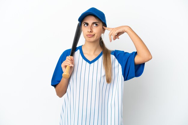 Joven mujer caucásica jugando béisbol aislado sobre fondo blanco con dudas y pensamiento