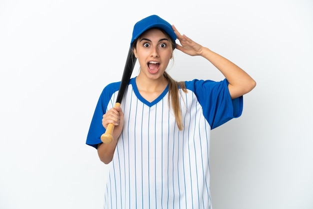 Joven mujer caucásica jugando béisbol aislado sobre fondo blanco con expresión de sorpresa