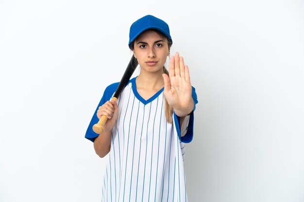 Joven mujer caucásica jugando béisbol aislado sobre fondo blanco haciendo gesto de parada