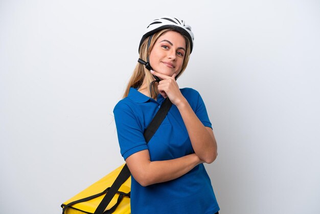 Joven mujer caucásica con mochila térmica aislado sobre fondo blanco sonriendo