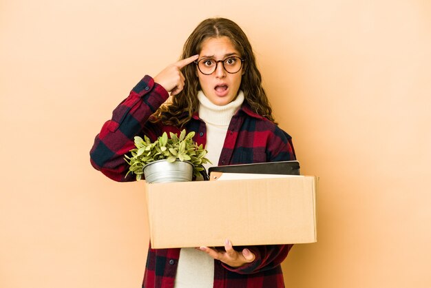 Joven mujer caucásica moviéndose sosteniendo una caja aislada