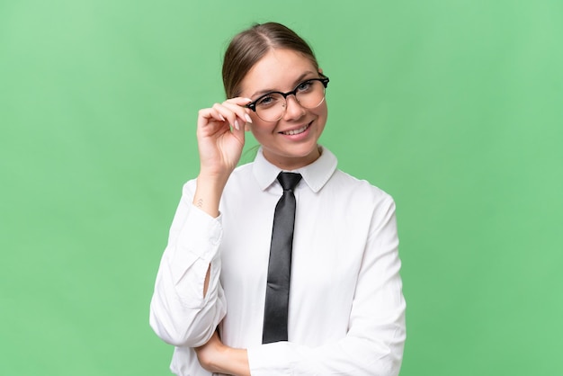 Joven mujer caucásica de negocios sobre un fondo aislado con gafas y feliz