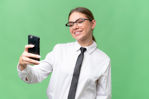 Joven mujer caucásica de negocios sobre un fondo aislado haciendo un selfie