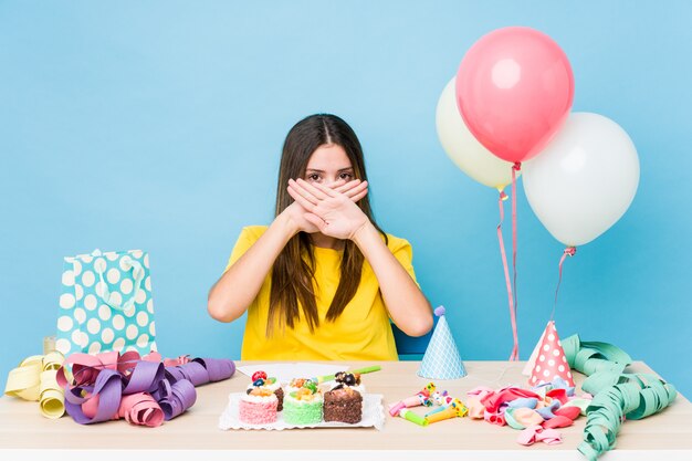 Joven mujer caucásica organizar un cumpleaños haciendo un gesto de negación