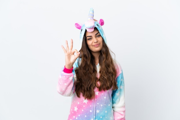 Joven mujer caucásica con un pijama de unicornio aislado de fondo blanco feliz y contando tres con los dedos