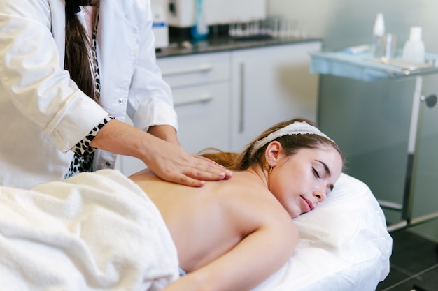 Joven mujer caucásica recibiendo un masaje en un centro de belleza