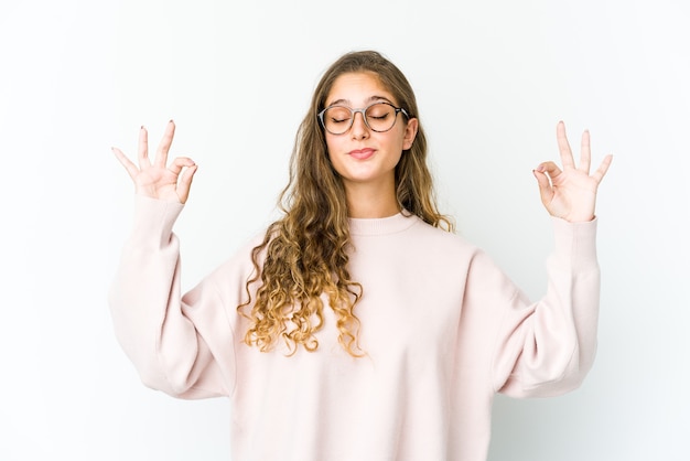 Joven mujer caucásica se relaja después de un duro día de trabajo, ella está realizando yoga.