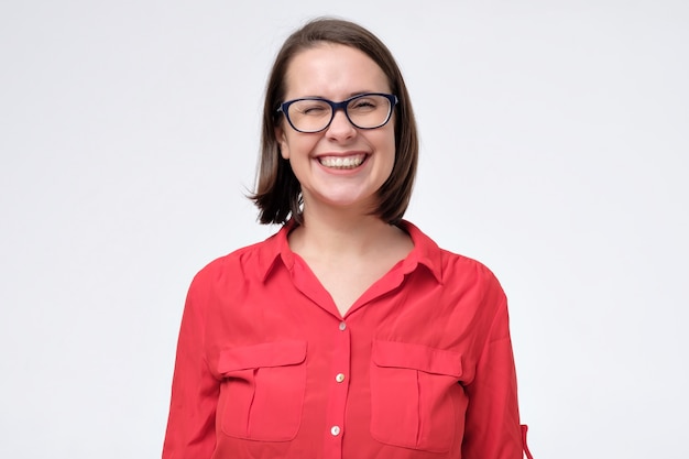 Joven mujer caucásica riendo con gafas riendo