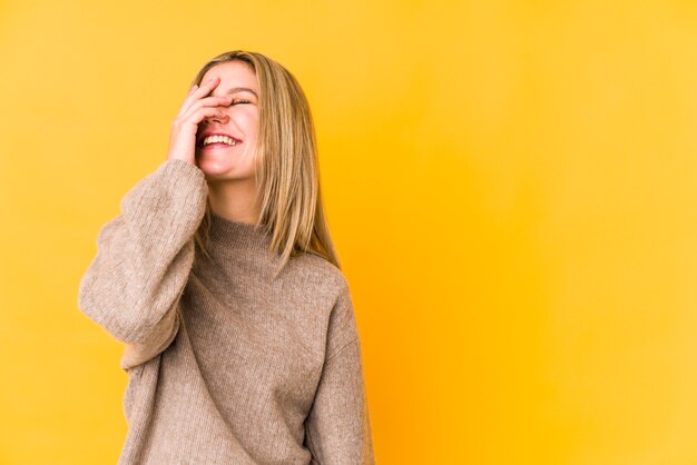 Joven mujer caucásica rubia aislada riendo emoción feliz, despreocupada, natural.