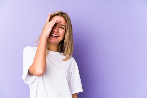 Joven mujer caucásica rubia aislada riendo emoción feliz, despreocupada, natural.