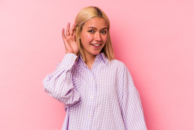 Joven mujer caucásica rubia aislada sobre fondo rosa