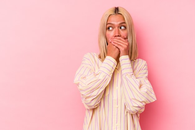 Joven mujer caucásica rubia aislada sobre fondo rosa