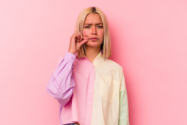 Joven mujer caucásica rubia aislada sobre fondo rosa