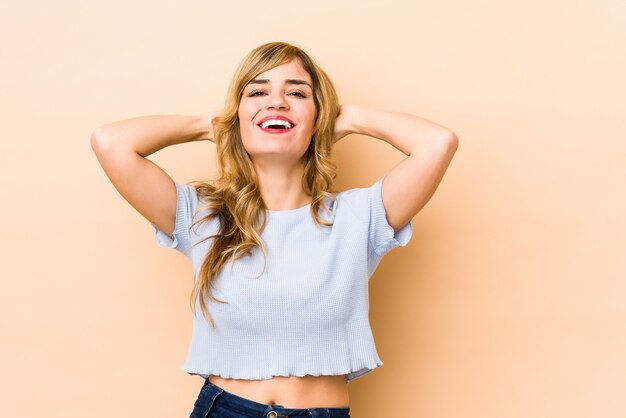 Joven mujer caucásica rubia gritando, muy emocionada, apasionada, satisfecha con algo.