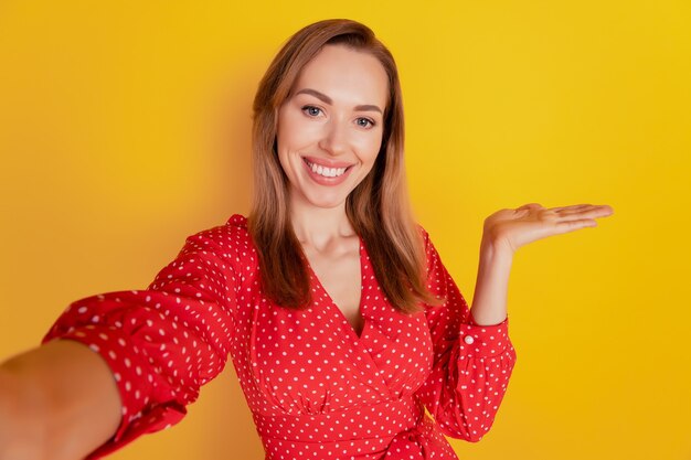 Joven mujer caucásica sobre fondo aislado sosteniendo copyspace en Palm disparar selfie